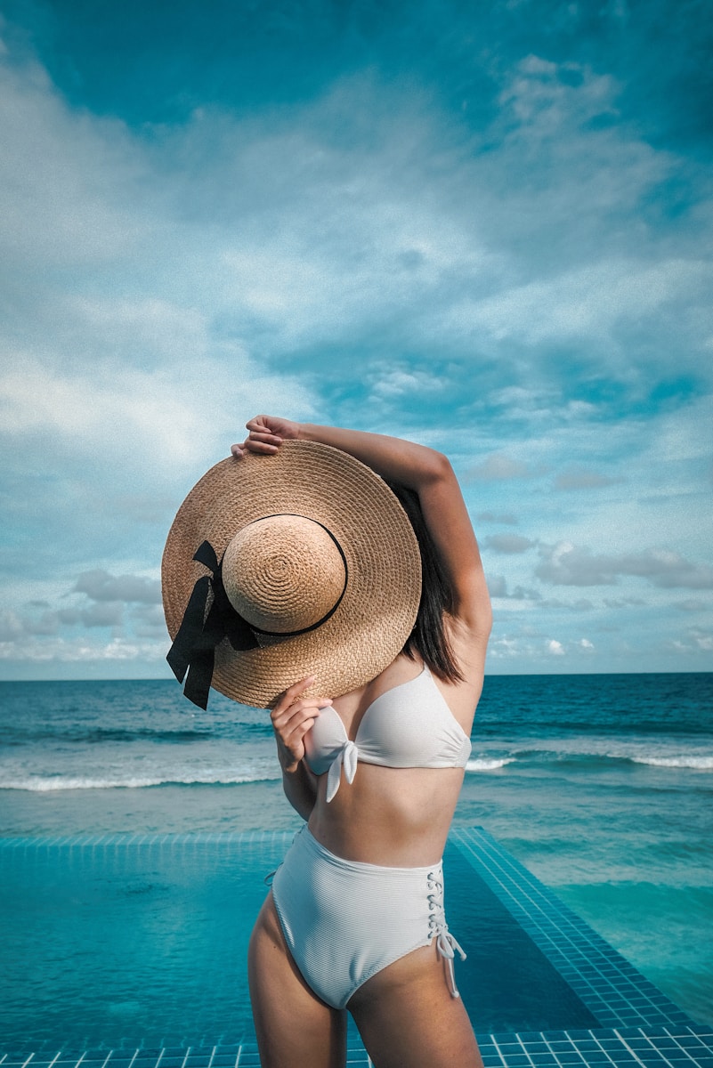 woman holding brown straw hat