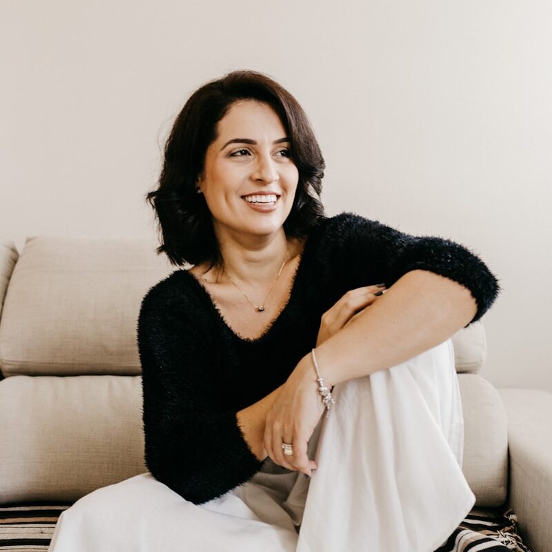 woman in black long sleeve shirt sitting on white couch