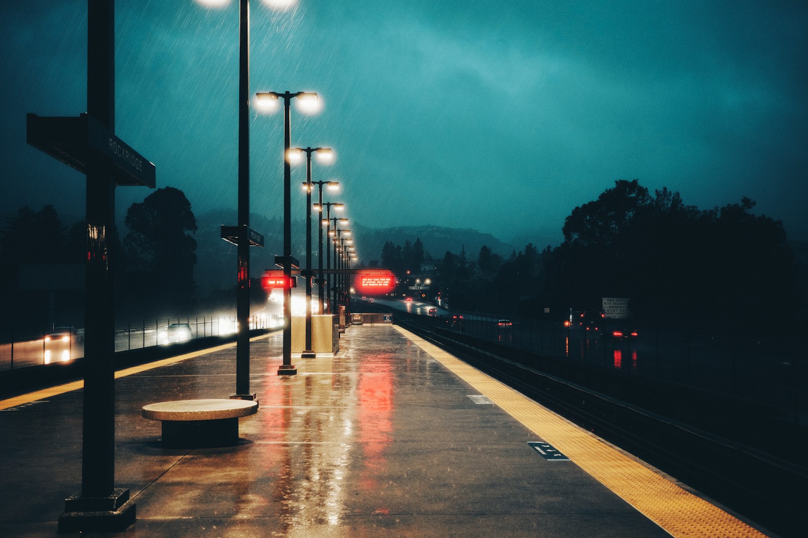 Empty train station platform at night with rain