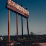 a large wooden sign sitting in the middle of a desert